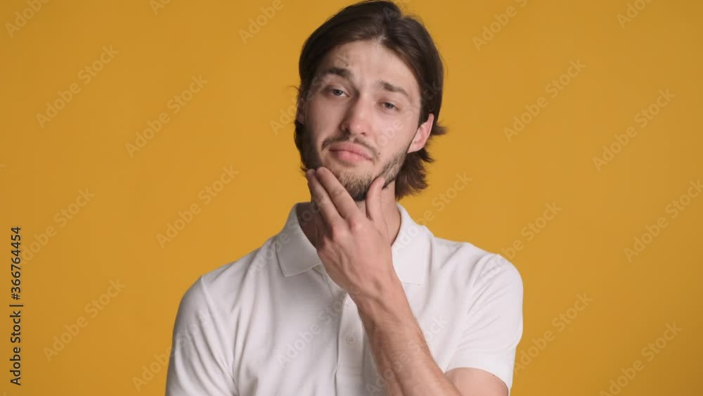 Attractive stylish guy thinking and waving yes on camera over colorful background. Thoughtful expression Attractive stylish guy thinking and waving yes on camera over colorful background. Thoughtful expression