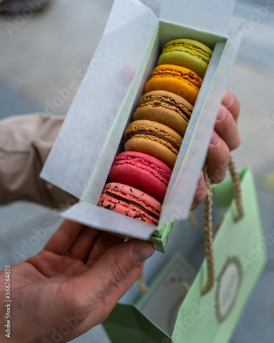 Photography close up of a woman holding macaroons