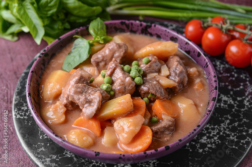 Bowl with tasty beef stew on table