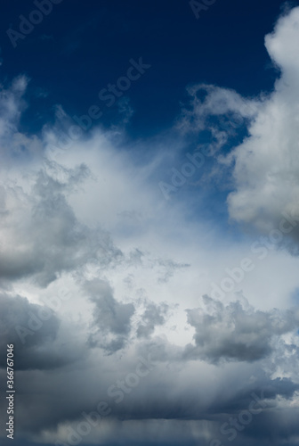 Beautiful blue sky background at daylight with white cumulus clouds. Vertical orientation