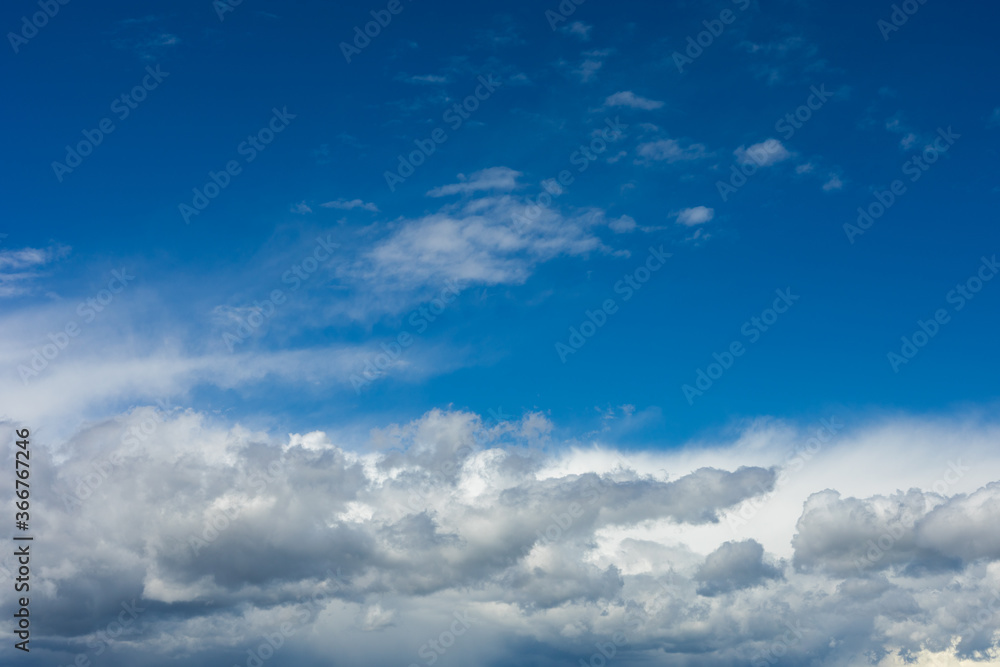 Beautiful blue sky background at daylight with white cumulus clouds.