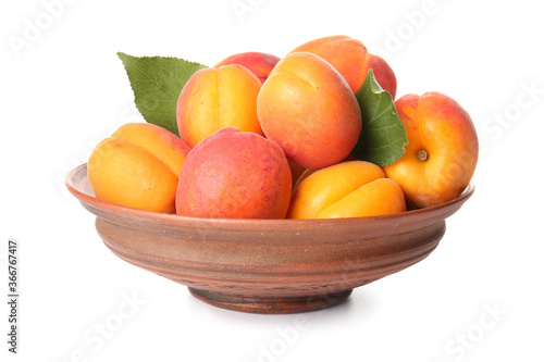 Bowl with tasty ripe apricots on white background