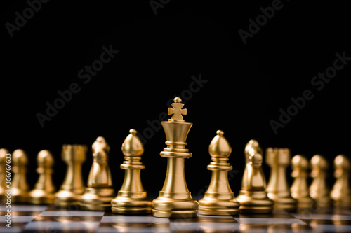Golden king chess stand in front of others chess pieces. Leadership business teamwork and marketing strategy planing concept.