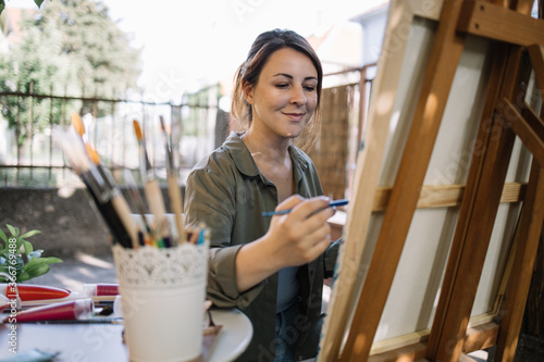 Foto Young female artist enjoying painting in backyard