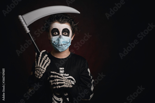 Happy Halloween. kid wearing medical mask in a skeleton costume with a scythe