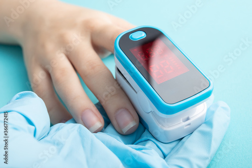 Diagnosis of diseases of the respiratory system with a pulse oximeter on a blue background