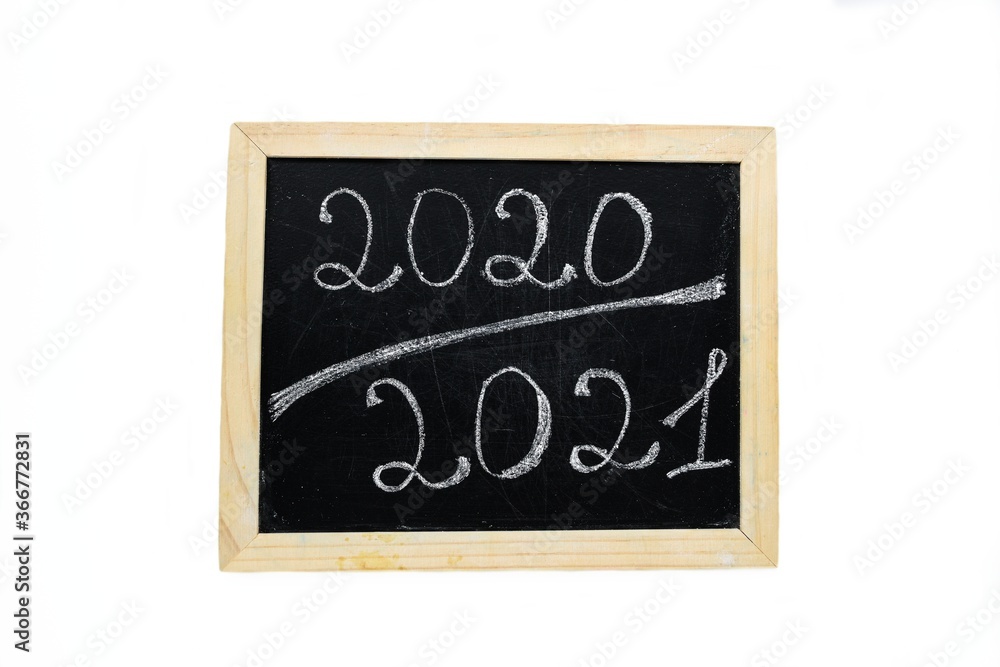 Obraz premium Inscription 2020 2021 chalk on a black chalkboard with a wooden frame on a white background.