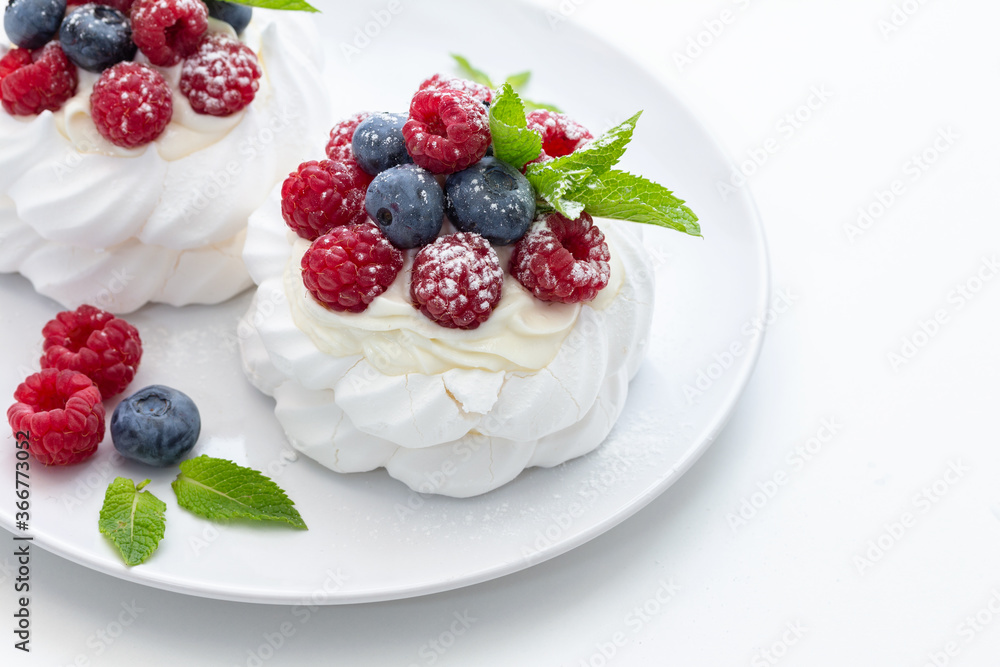 mini Pavlova dessert with raspberries and blueberries on the table mini Pavlova dessert with raspberries and blueberries on the table