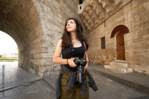 Female tourist is visiting historical places with camera. Photographer who visits historical places. The blogger who is happy to see new places. A woman going on a trip with a backpack and a camera.  © mercankaya