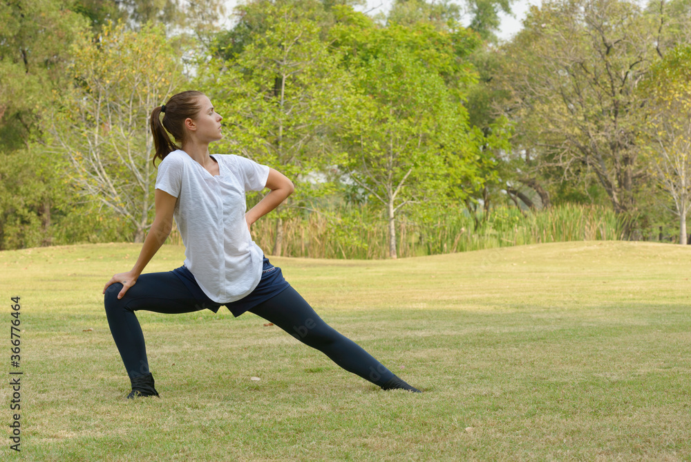 Young beautiful woman exercising at the park outdoors