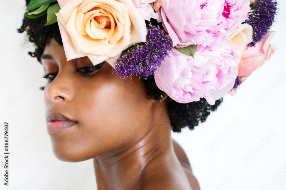 Young black woman with afro and flowers in her hair Young black woman with afro and flowers in her hair