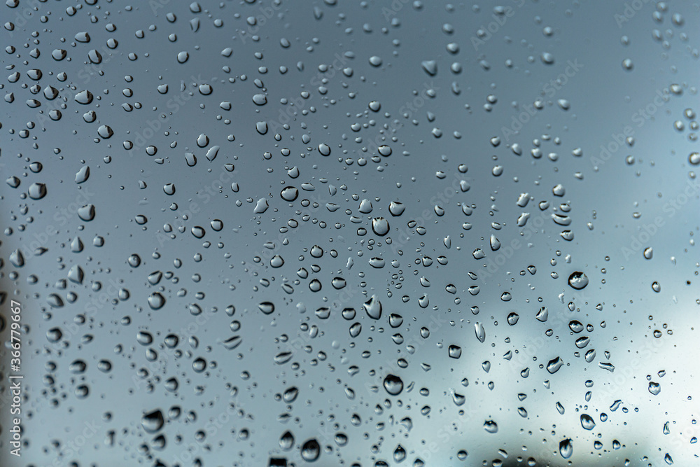 Rain drops on window glass, natural background of rainy season.