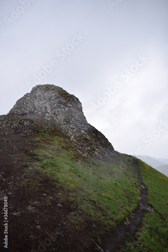 A rocky hill on a foggy, cloudy day