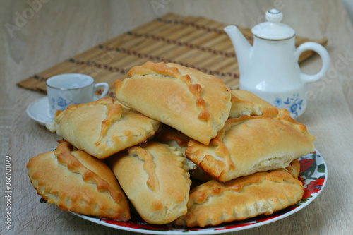 Delicious pies on a beautiful plate on the background of a tea set