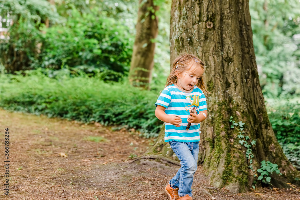 Toddler girl running in forest Toddler girl running in forest