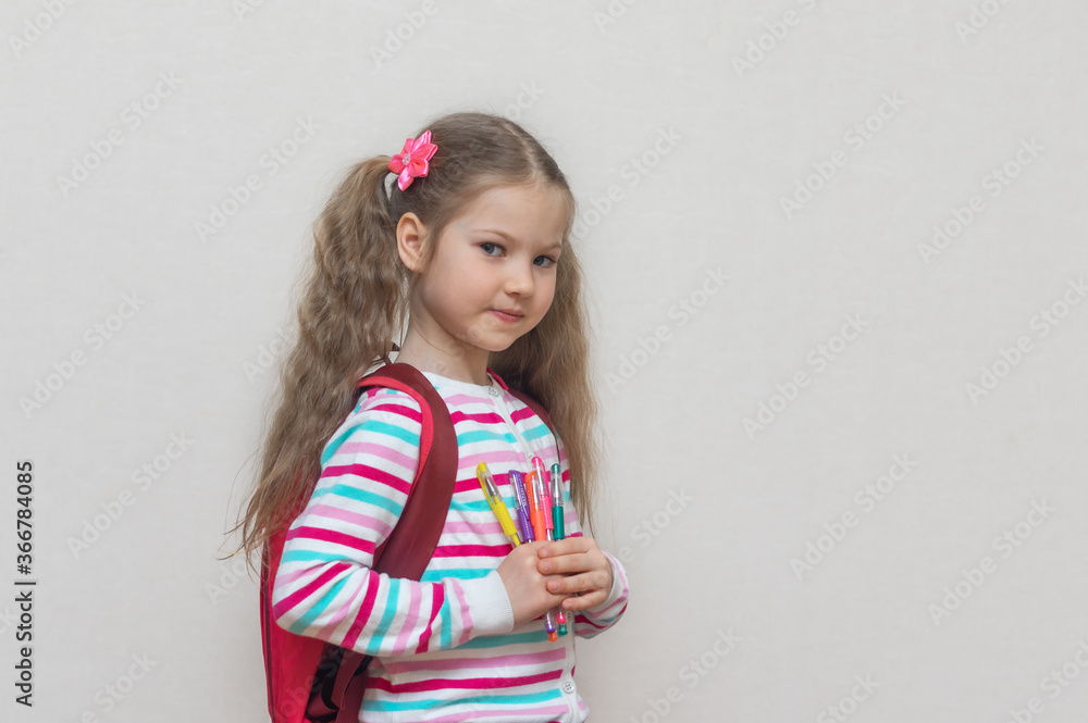 Back to school. Portrait of blonde schoolgirl in jacket with colored gel pens. The girl is smiling and looking at camera. Light background. Education. Preparation for school. copy place. Back to school. Portrait of blonde schoolgirl in jacket with colored gel pens. The girl is smiling and looking at camera. Light background. Education. Preparation for school. copy place.