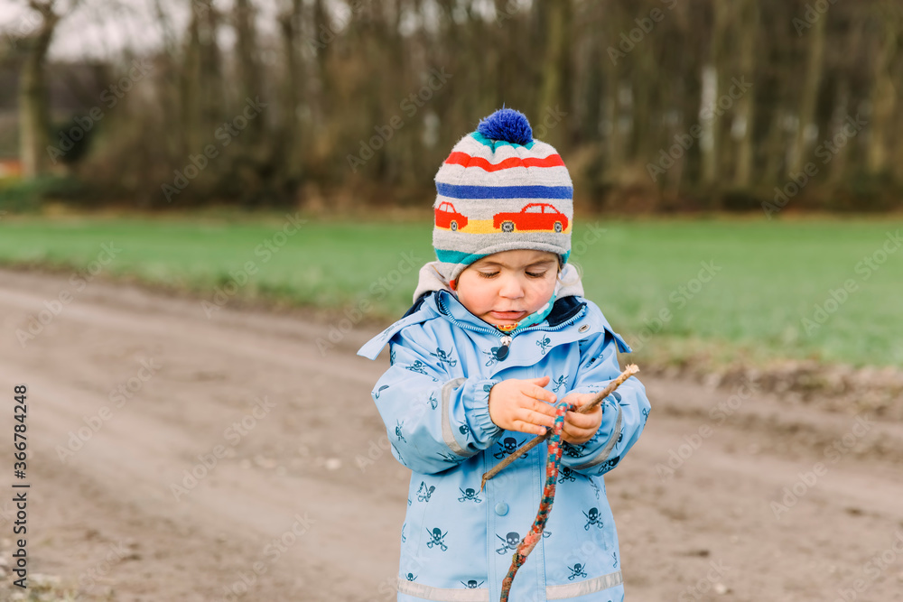 Toddler girl holding stick and rope Toddler girl holding stick and rope