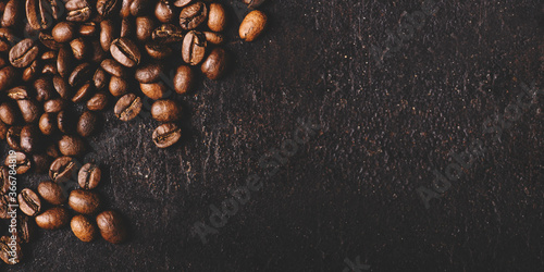 Coffee beans on rustic black background from above. Coffee shop creative menu design layout.
