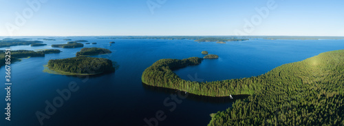 Aerial view of of islands on a blue lake Paijanne. Blue lake, islands and green forest from above on a sunny summer evening. Lake landscape in Finland photo