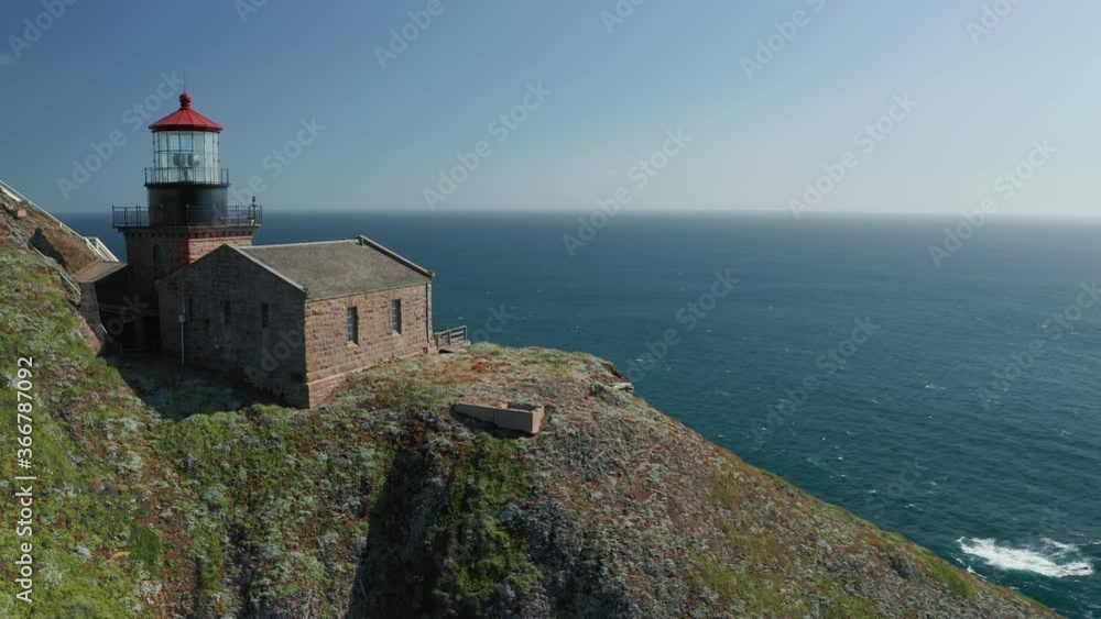 Cinematic old lighthouse with red roof on the edge of the sheer cliff of the high mountain. Scenic seascape on motion background. Inspirational aerial for travel background. California USA, 4K footage Cinematic old lighthouse with red roof on the edge of the sheer cliff of the high mountain. Scenic seascape on motion background. Inspirational aerial for travel background. California USA, 4K footage