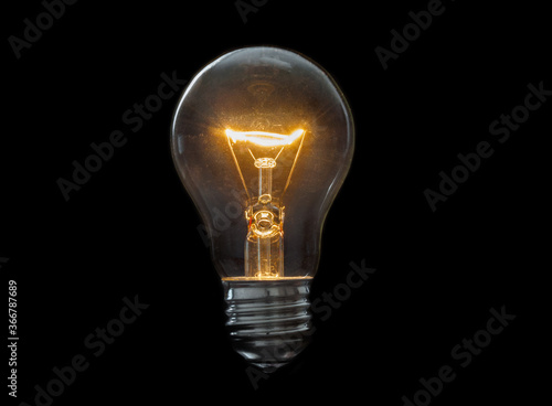 Old, dirty light bulb close up on black background photo