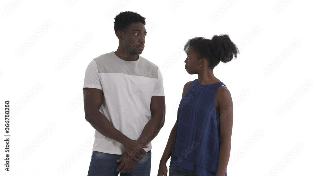 Portrait of African American couple. Young man dropped his jaw in great astonishment as if he gazing after somebody very attractive. Jealous girl slapping him on mouth. Isolated on white background Portrait of African American couple. Young man dropped his jaw in great astonishment as if he gazing after somebody very attractive. Jealous girl slapping him on mouth. Isolated on white background