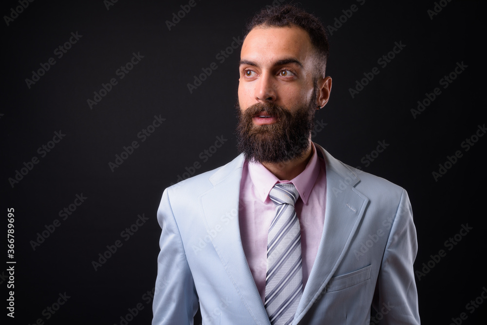 Young handsome Persian businessman with dreadlocks against black background Young handsome Persian businessman with dreadlocks against black background