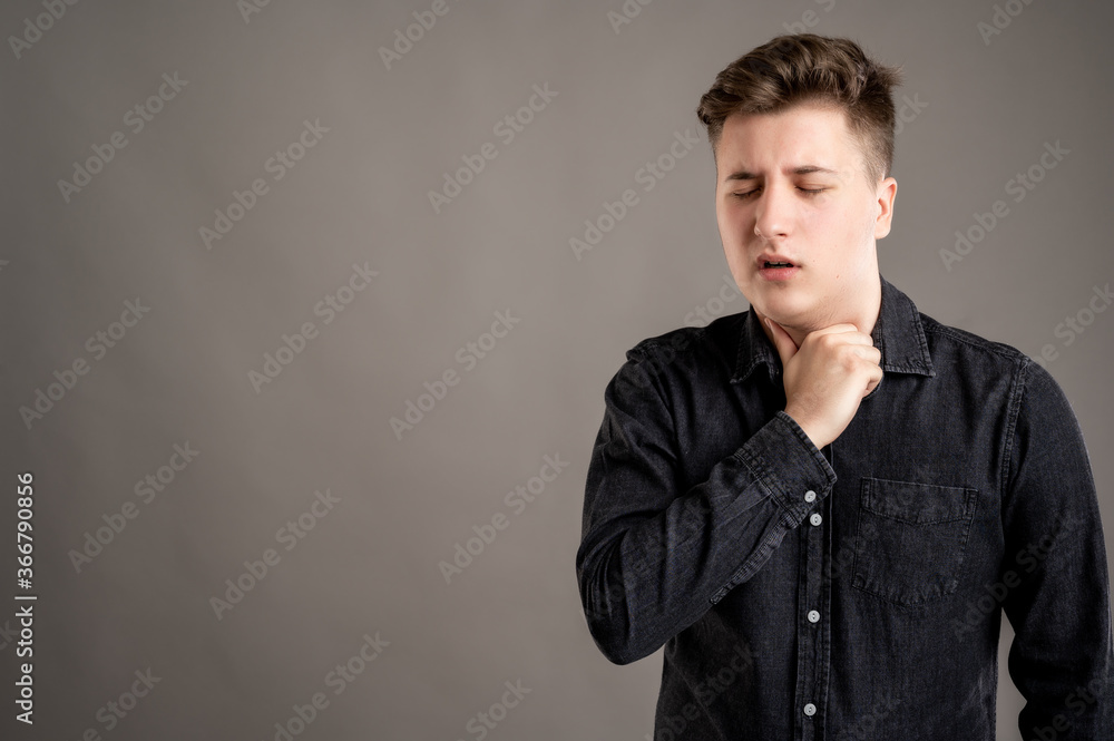 Portrait of serious stylish attractive man dressed with a casual black shirt gesturing neck ache Portrait of serious stylish attractive man dressed with a casual black shirt gesturing neck ache
