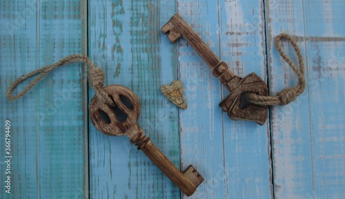 Two wooden keys on an aged blue background.