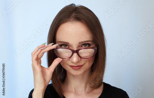 Girl student with glasses on a bluish background