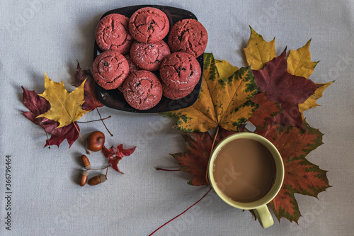 Cup of coffee with cranberry cookies and autumn multicolored maple leaves with acorns . Autumn concept. View from above