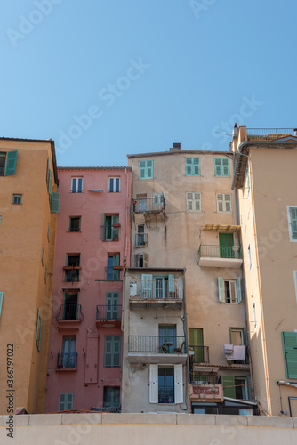 Old, vintage residential buildings by the promenade in Menton, south of France. Balconies and windows with shutters. 