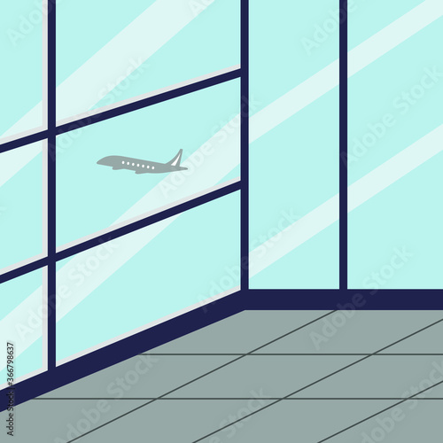 A room with glass walls and a flying airplane outside the window