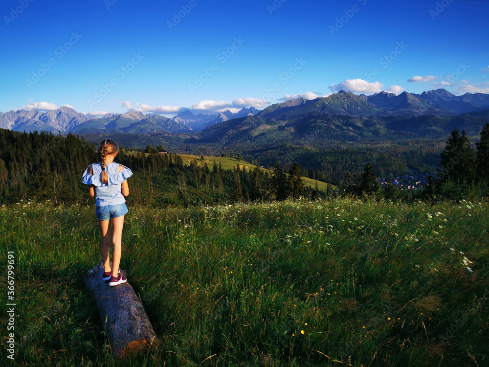 Naklejka premium Bukowina Podhale Poland. Little girl on the background of the Tatra Mountains. Holidays in the mountains.