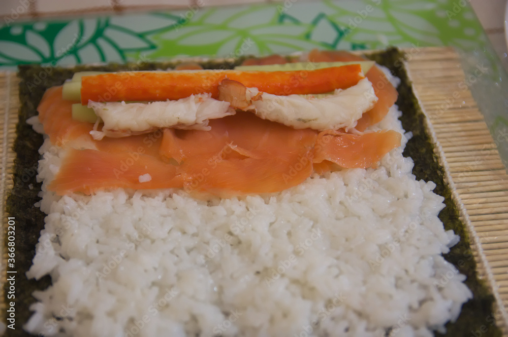 Making sushi with rice, fish, vegetables and nori seaweed Making sushi with rice, fish, vegetables and nori seaweed