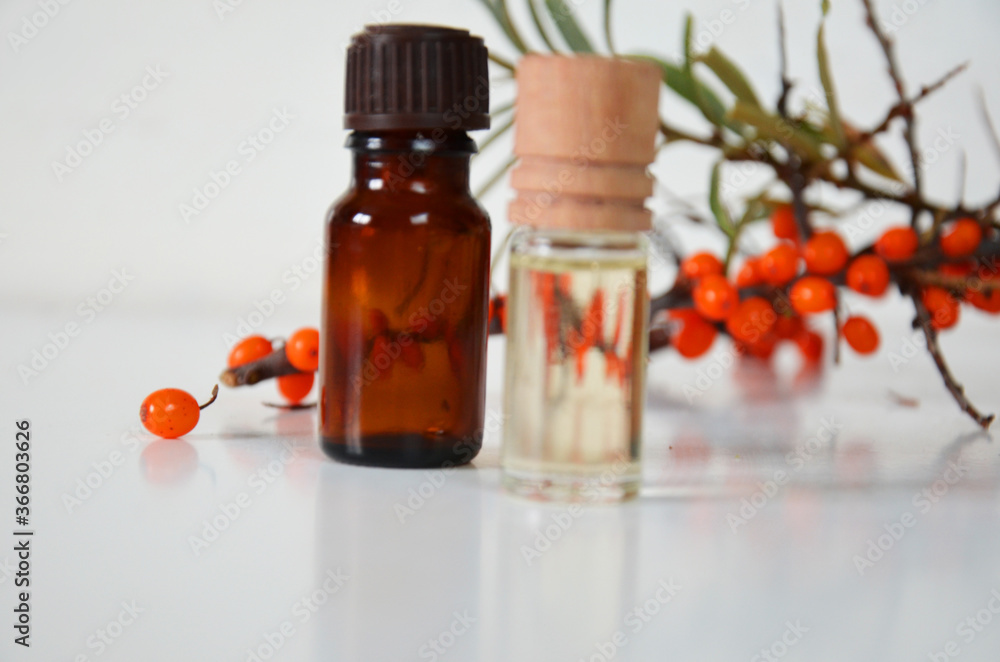 sea-buckthorn berries cluster and oil bottle jar isolated on a white background sea-buckthorn berries cluster and oil bottle jar isolated on a white background