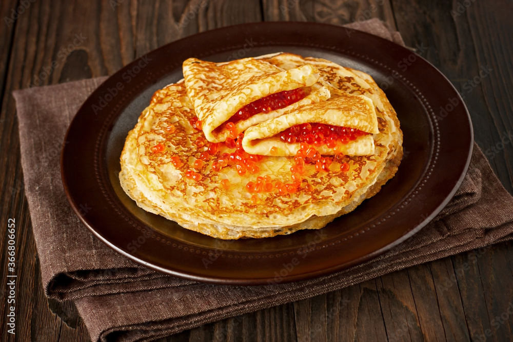 Pancakes stack with red caviar on plate Pancakes stack with red caviar on plate