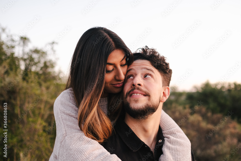 Delighted ethnic girlfriend and boyfriend embracing looking at each other in the mountain Delighted ethnic girlfriend and boyfriend embracing looking at each other in the mountain