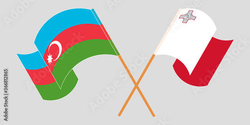 Crossed and waving flags of Malta and Azerbaijan