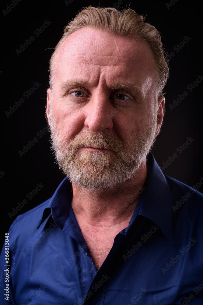 Mature handsome bearded man with blond hair against black background Mature handsome bearded man with blond hair against black background