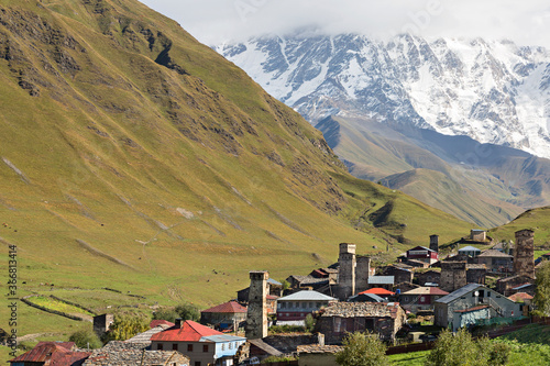Mountain village Ushguli with medieval towers and one of the peaks of the Caucasus Mountains, Mount Shkhara in the background, Georgia, Caucasus photo