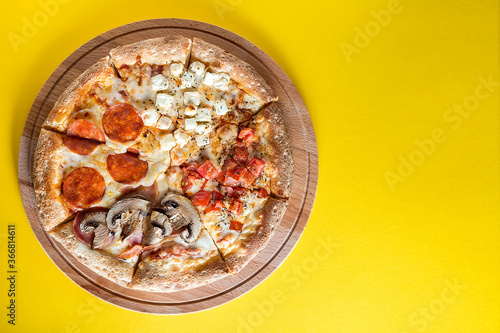 Pizza with vegetables on a bright yellow background.