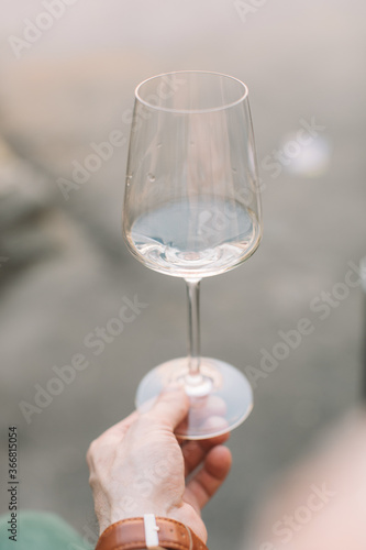 Man holding glass of wine outdoors.