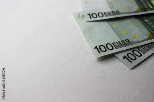 Close-up of 100 Euro banknotes isolated on white background. Currency, financial