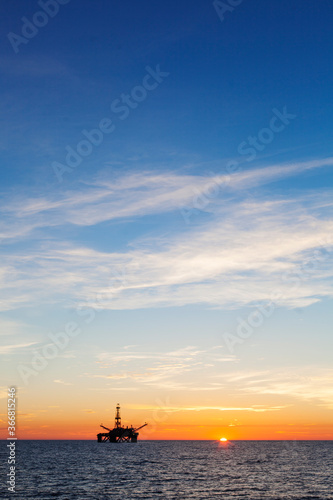 Oil platform at sunset, vertical view