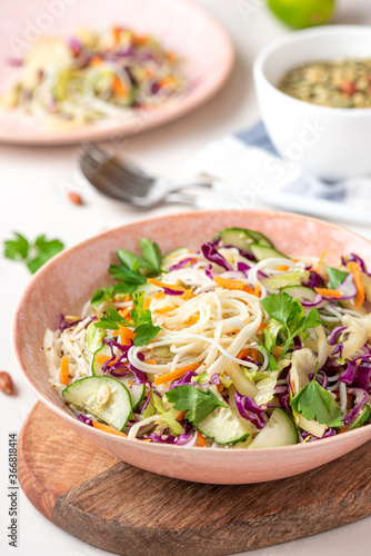 Vegetarian food. Salad with noodles, vegetables and sesame seeds in a bowl close-up. Tasty and healthy food.