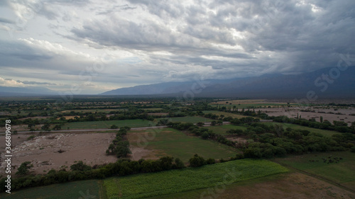 Agrarian landscape. Agriculture. Aerial view of the rural field plantations growing alfalfa and crops in the mountains at nightfall. 