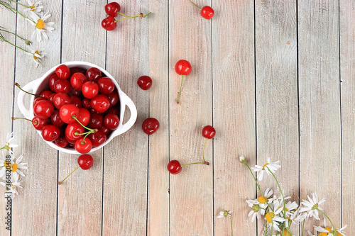 Fresh berries of cherries in a basket on a light table, top view, sweet cherry on a wooden light background, selective focus. Natural food concept, healthy breakfast, harvesting