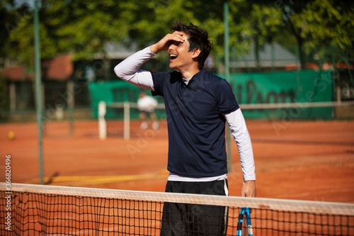 tennis player laughing while holding his head © kevin