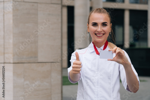 Portrait of a gay happy doctor holding a plastic card in front of the camera photo